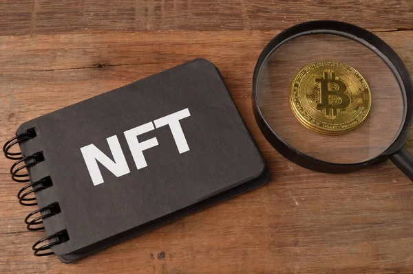 Altın Bitcoin ve NFT ile yazılmış not defteri NON FUNGIBLE TOKENS anlamına gelir