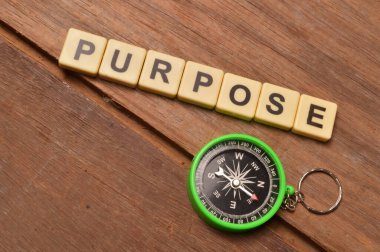 Üst görünüm pusula ve metni PURPOSE ile kare harfler. İş ve eğitim kavramı.