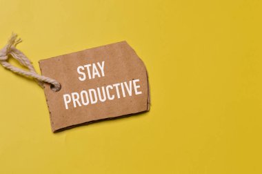 STAY PRODUCTIVE ile yazılmış notun üst görünümü. İş ve eğitim kavramı.