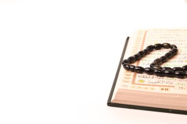 Kur 'an ya da Kur' an-ı Kerim ve tespih beyaz bir zemin üzerinde kopyalanmış..