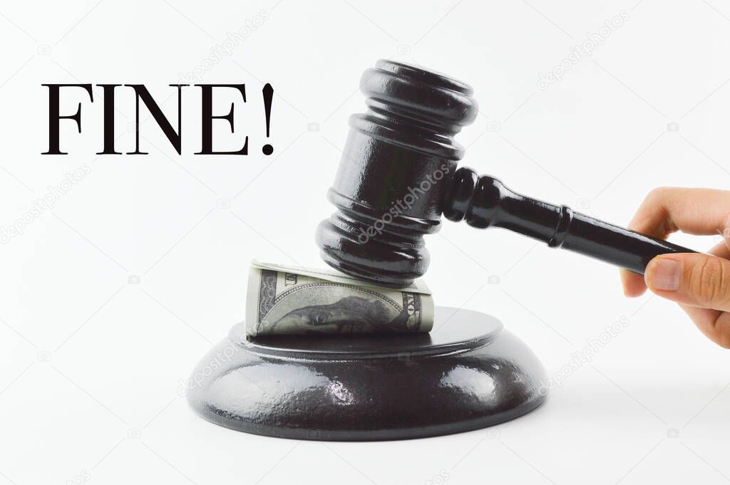 Front view of judge gavel and money banknote over white background written with text FINE!