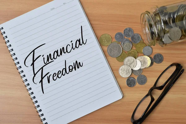 Ovanifrån Glasögon Mynt Och Anteckningsbok Skriven Med Finansiell Freedom — Stockfoto