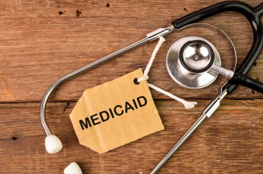 Metin MEDICAID ile yazılmış steteskop ve etiket etiketinin üst görünümü.