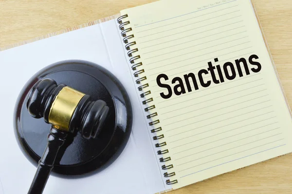 Hakim tokmağı ve not defterinin SANCTIONS tarafından yazılan üst görünümü