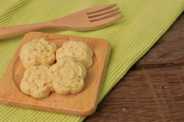 Bayramda servis edilen tahtadan tabakta KUIH BANGKIT Peyniri adı verilen geleneksel Malezya kurabiyeleri.