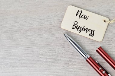 NEW BUSINESS ile yazılmış kalem ve etiket üst görünümü