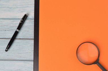 Kalemin üst görüntüsü, büyüteç ve fotokopi alanı olan turuncu kağıt. İş konsepti.