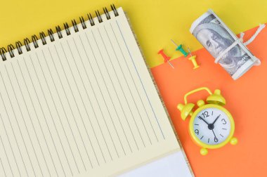 Saatin üst görüntüsü, para banknotu, pim tahtaları ve fotokopi alanı olan defter. İş konsepti.