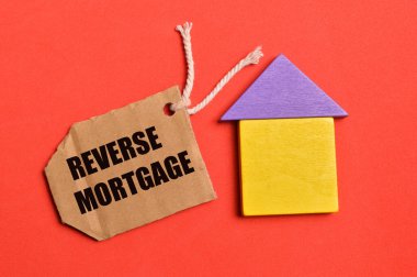Oyuncak ev ve etiket üst görünümü REVERSE MortGage ile yazılmış. Emlak kavramı.