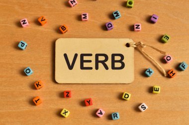 VerB ile yazılmış renkli alfabe boncukları ve etiket etiketlerinin üst görünümü. Eğitim kavramı.