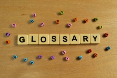 Renkli alfabe boncukları ve metin GLOSSARY ile kare harfler.