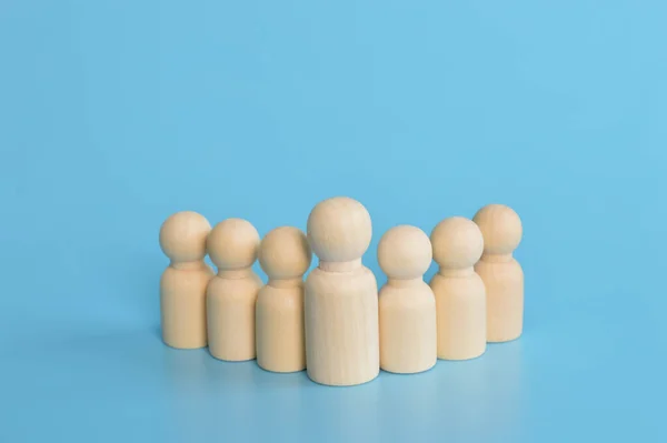 Wooden doll figures in a row. Social workers and leader concept.
