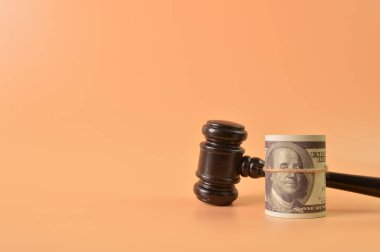 Yargıç Tokmak ve para banknotu, fotokopi alanı olan turuncu arka planda izole edilmiş..