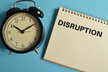 DISRUPTION ile yazılmış saat ve defter üst görünümü