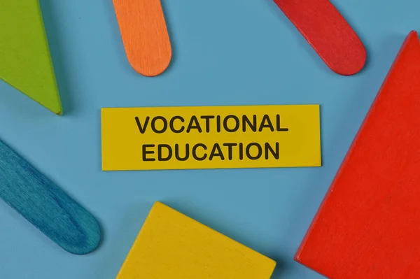 Top view of colorful wooden blocks and memo note written with VOCATIONAL EDUCATION