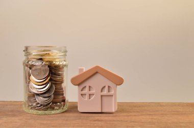 Oyuncak ev ve kavanozdaki bozuk paralar.