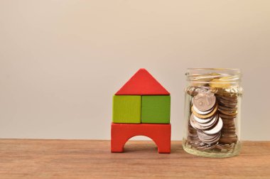 Tahta oyuncak ev ve kavanozdaki bozuk paralar..