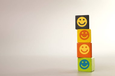 Wooden blocks with happy face symbols. Customer evaluation and satisfaction concept.