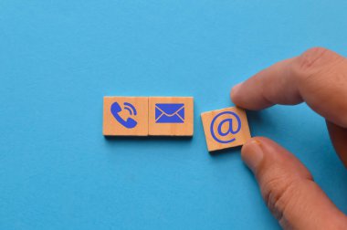 Telefon, e-posta ve adres simgesi olan tahta blok. Web sitesi bizimle ya da e-posta pazarlama konseptiyle iletişime geçin.