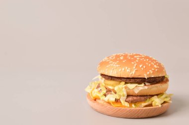 Gri arkaplanda çift peynirli burger.