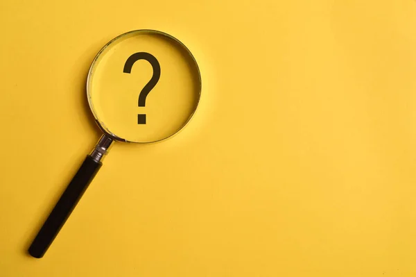 Top view of magnifying glass and question mark isolated on yellow background. Copy space