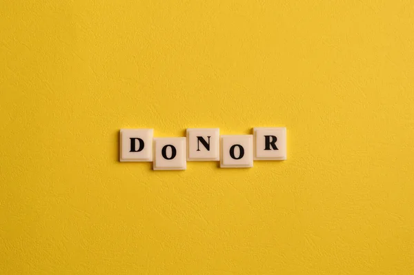 Letras Quadradas Com Texto Donor Isolado Fundo Amarelo — Fotografia de Stock