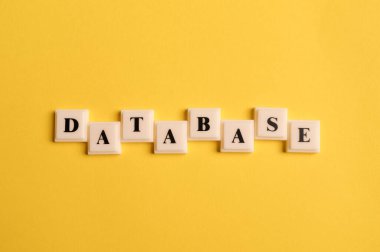 Sarı arkaplanda izole edilmiş DATABASE metin içeren kare harfler