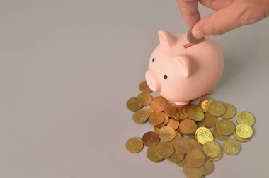 Elin üst açılı görüntüsü parayı kumbaraya koyuyor.