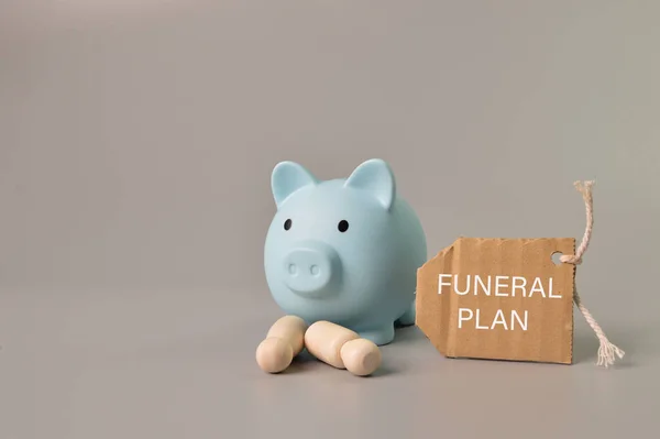 Domuz kumbarası, insan figürleri ve etiket FUNERAL PLAN ile yazılmış