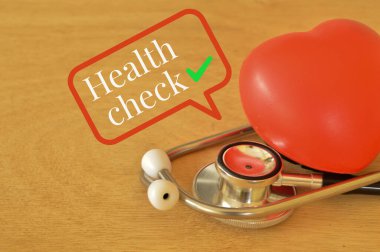 Kırmızı kalp şekli ve steteskop ile metin sağlığı kontrolü