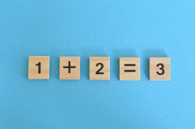 Tahta küp bloklar, bir artı iki eşittir üç. Matematik kavramı