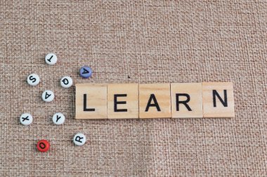 Alfabe boncukları ve kare harflerle LEARN