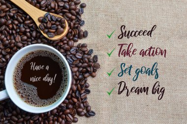 Kahverengi kahve çekirdekli kavrulmuş kahve ve bir fincan kahve. Yazılı, berbat, eyleme geçen, belli hedefler ve büyük bir rüya.