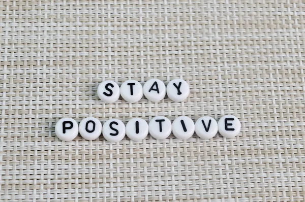 Grânulos Alfabeto Com Texto Stay Positive Isolado Fundo Marrom — Fotografia de Stock