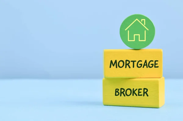 Wooden blocks with home symbol and text MORTGAGE BROKER