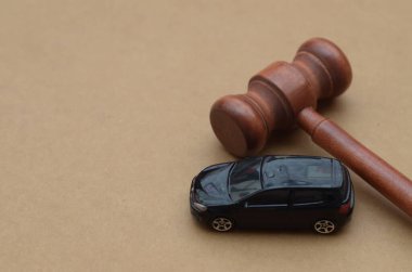 Bir arabanın yanındaki tokmak trafik kurallarını, trafik ihlallerini, sigorta taleplerini ve araba kullanmanın yasal sonuçlarını simgeler..
