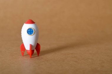 Kalkışa hazır kırmızı ve beyaz bir oyuncak roket, yeni bir fikri, iş girişimini veya başarılı bir projenin başlangıcını temsil ediyor..