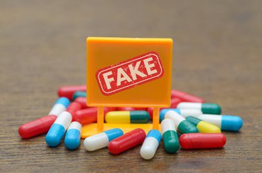 Tehlike: Sahte İlaçlar: Renkli haplarla çevrili kırmızı bir 