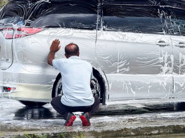 Klang, Malaysa: 15 Kasım 2025 - Profesyonel Araba Yıkama İşçisi Açık Tente Altındaki Aracı Temizliyor
