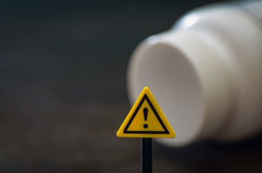 Dökülen İlaç Şişesinin Önündeki Dikkat İşareti Uyuşturucu Güvenliğini Temsil Ediyor