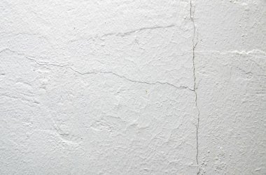 Beyaz duvardaki dikey çatlak, zamanla yapısal gerilimi, temel hareketini ve bina aşınmasını gösteriyor..