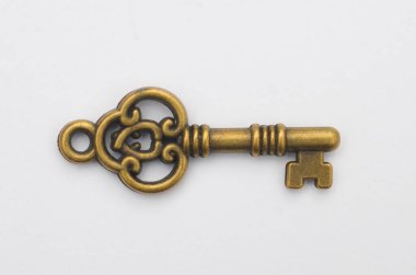 Beyaz Arkaplanda Çembersel Yay ve Haç Biçimli Eski Pirinç İskelet Anahtarı.