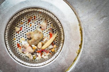 Mutfak lavabosu yemek artıkları ve ev atıklarıyla dolu.