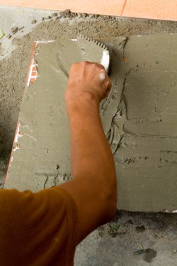 İş yerinde bir çatı ustası. zemini fayans yapıştırıcı ile bağ