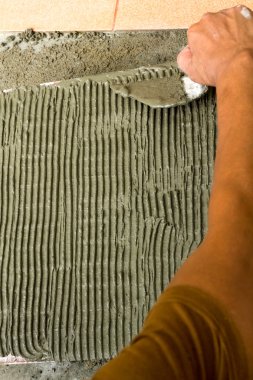 İş yerinde bir çatı ustası. zemini fayans yapıştırıcı ile bağ