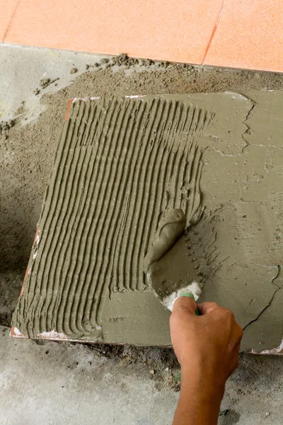 Fliesenleger bei der Arbeit. Verklebung von Bodenfliesen mit Fliesenkleber — Stockfoto