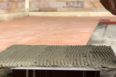 İş yerinde bir çatı ustası. zemini fayans yapıştırıcı ile bağ