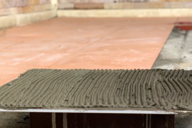 İş yerinde bir çatı ustası. zemini fayans yapıştırıcı ile bağ