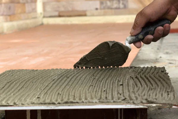 İş yerinde bir çatı ustası. zemini fayans yapıştırıcı ile bağ