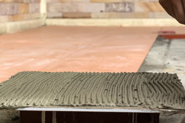 İş yerinde bir çatı ustası. zemini fayans yapıştırıcı ile bağ
